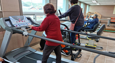 재활운동 교실에서 런닝머신과 사이클 머신을 이용하여 운동중인 주민들 모습