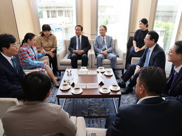 작은 테이블을 중간에 두고 모여앉아 대화중인 관계자들(크게보기)