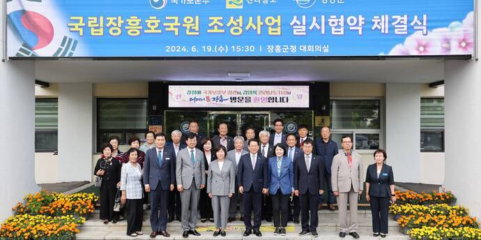 국립장흥호국원 조성사업 실시협약 체결식 2024.6.19(수) 15:30 장흥군청 대회릐실 현수막을 위에 걸고 건물앞에서 다함께 사진찍는 관계자들(크게보기)