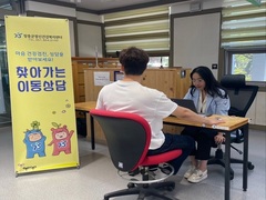 장흥군정신건강복지센터 마음 건강검진 상담을 받아보세요! 찾아가는 이동상담 글귀 앞에서 상담중인 모습.