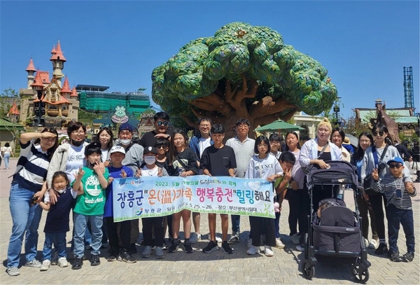 온가족행복충전 문화체험 행사에 참여한 가족들이 현수막(장흥군 온가족 행복충전 힐링해요!)을 들고 단체기념촬영을 하고있는 모습