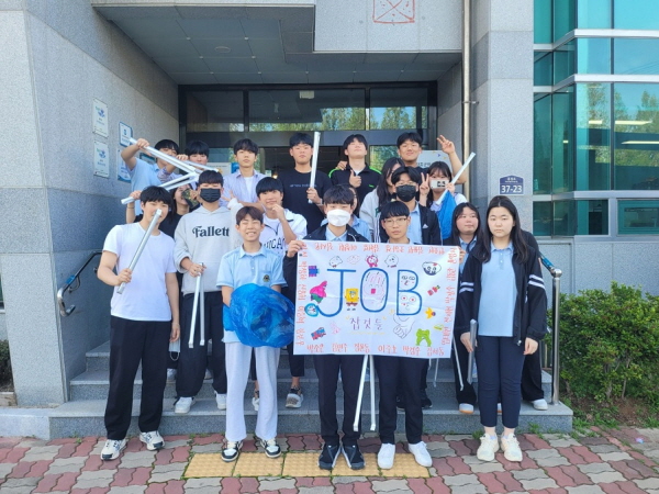 청소년 동아리연합회  진로탐색 동아리 ‘JOB것들’ 플로깅 활동에 참여한 청소년들이 집게와 비닐 팻말 등을 들고 기념촬영을 하고 있는 모습